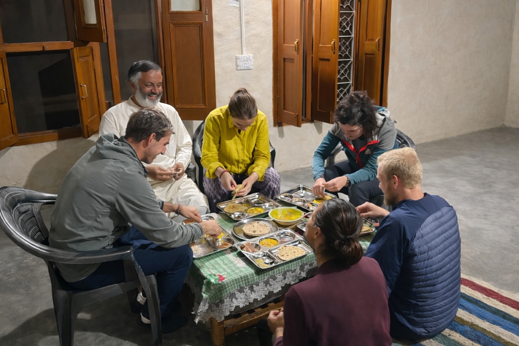 Group of people sitting on floor mats eating together