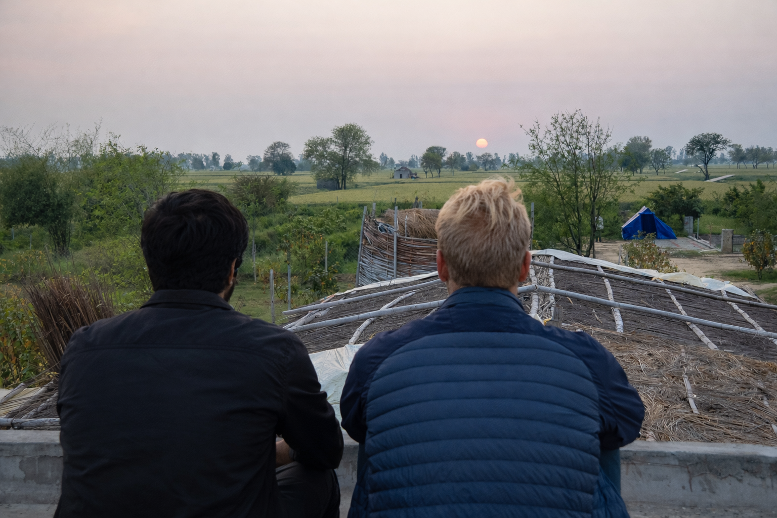 Two people sitting and watching the view from a roof