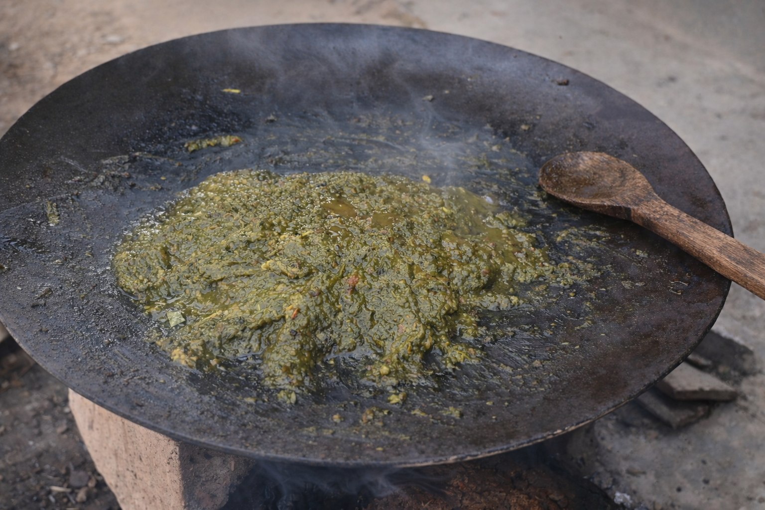 Green leafy vegetable dish cooking on fire